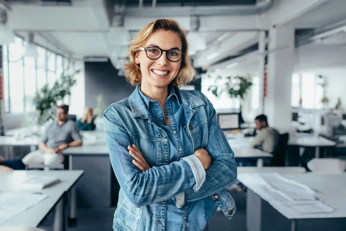 Happy female designer standing in office.