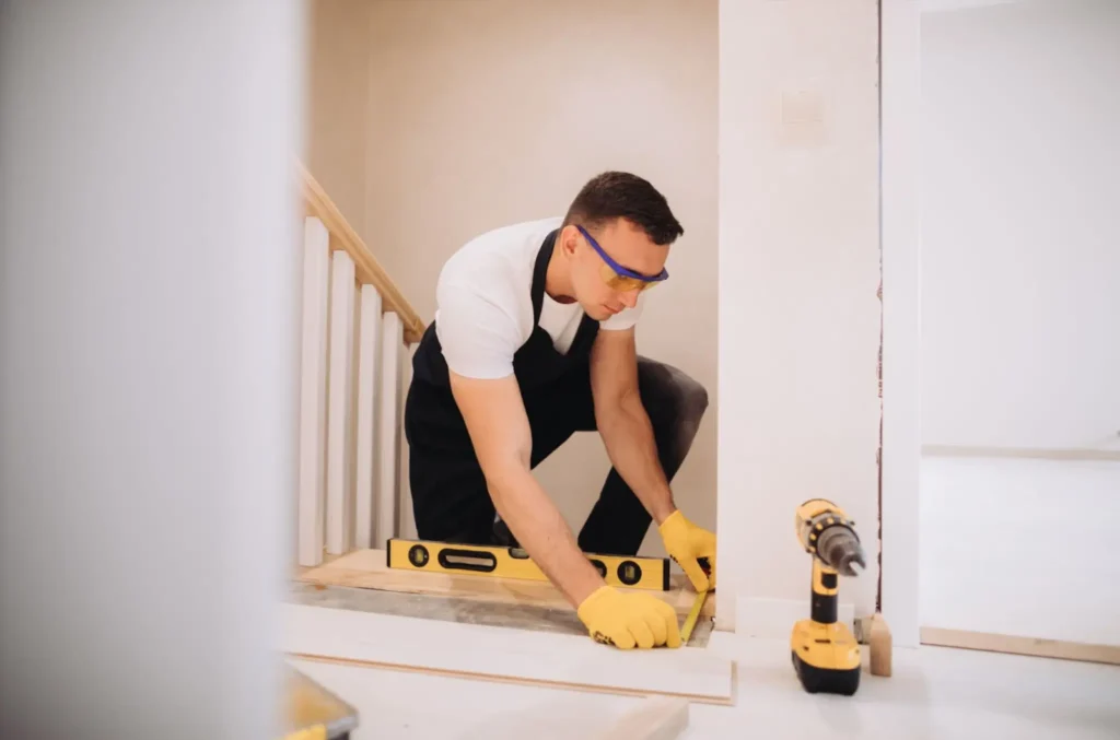 Local handyman checks stair alignment using a level tool.