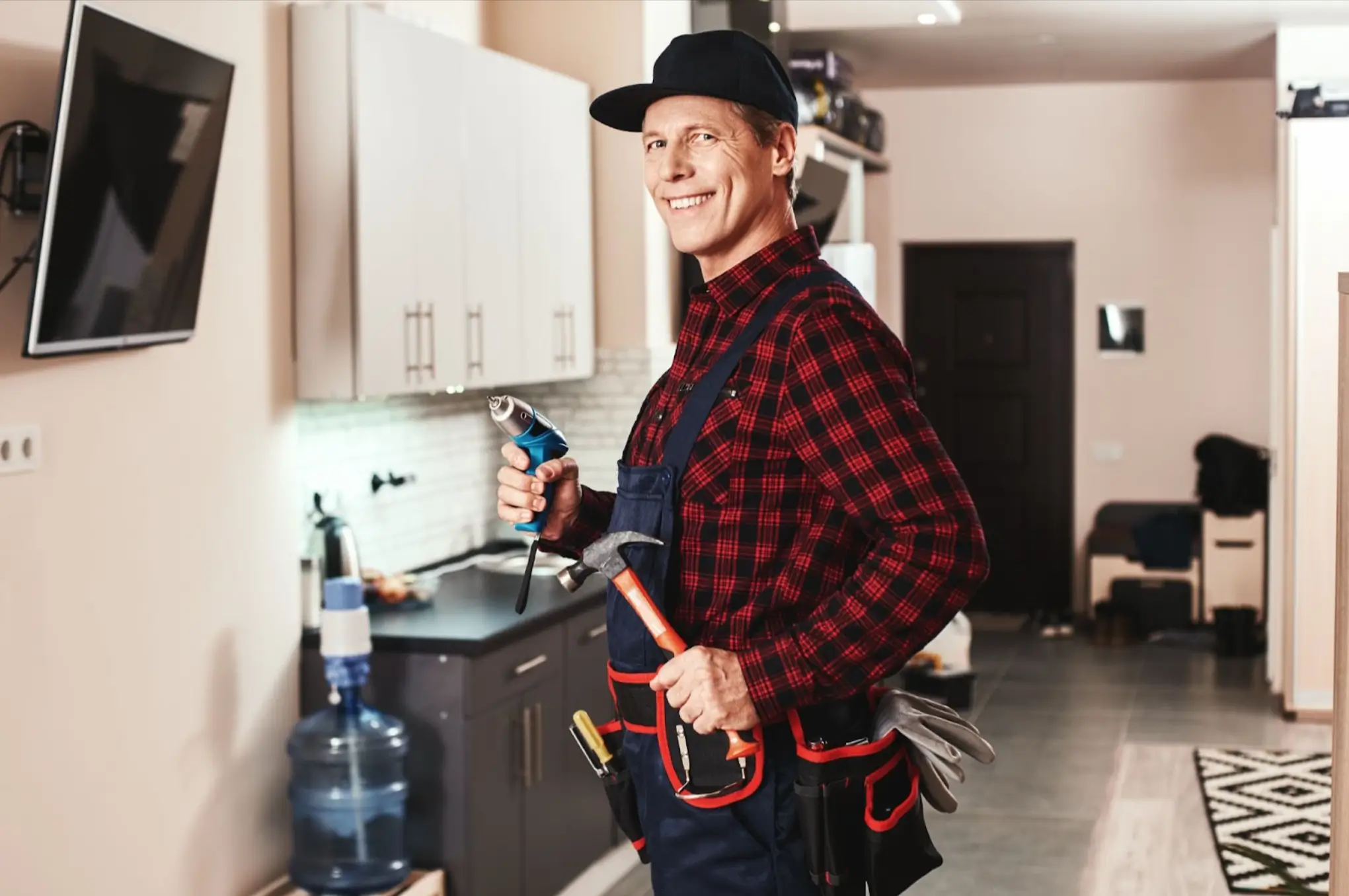 Side view of a smiling local handyman carrying tools and equipment, ready for repair work.
