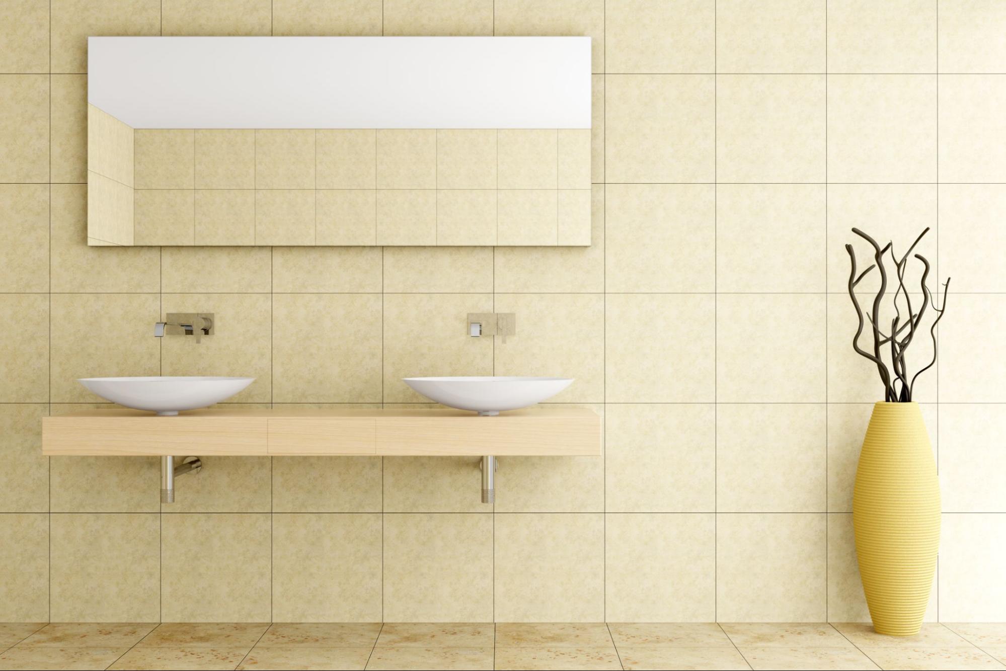 Modern bathroom with beige ceramic tiles on walls and floor, accented by a large yellow vase holding dried twigs.