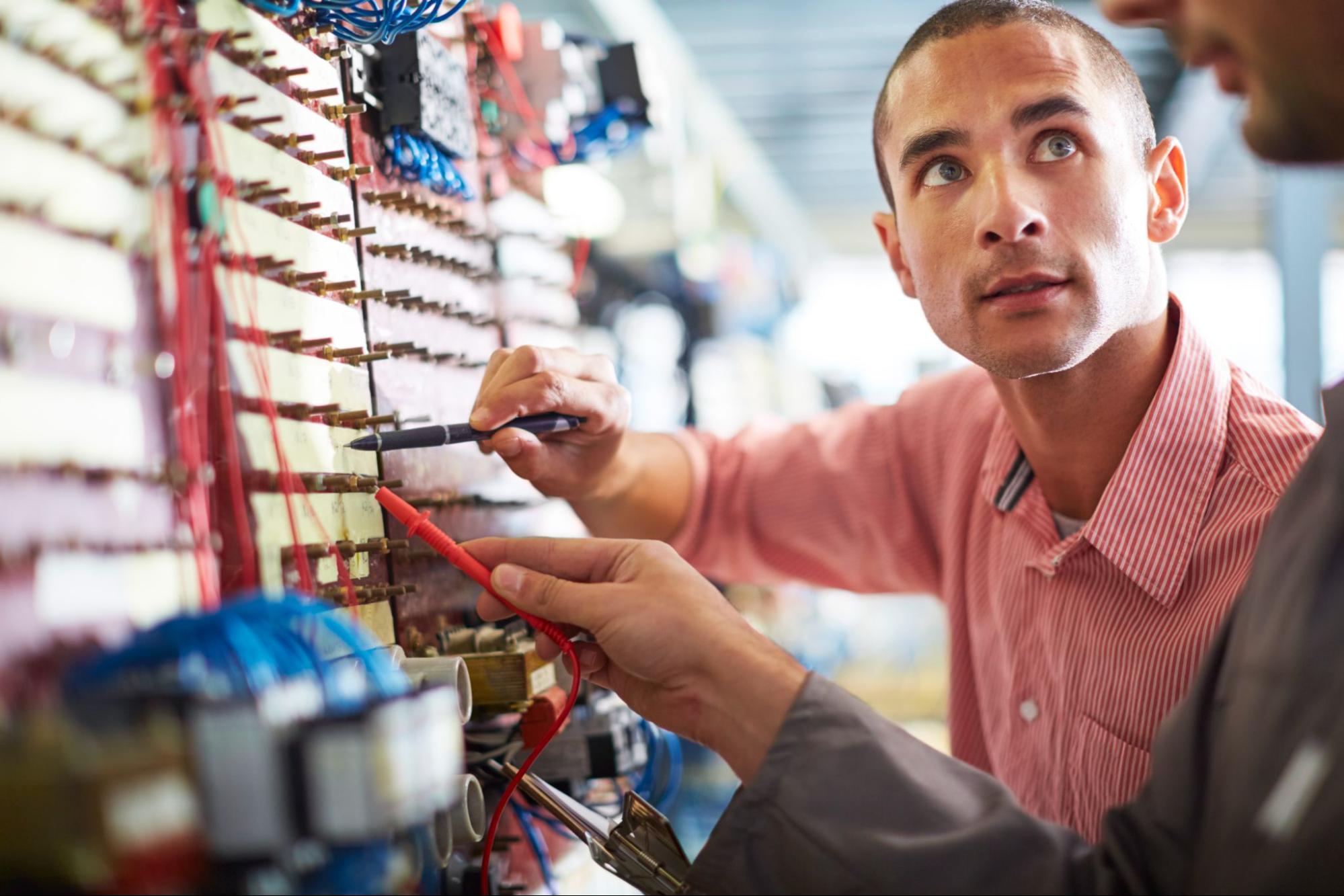 Two licensed electricians inspecting a building’s electrical system